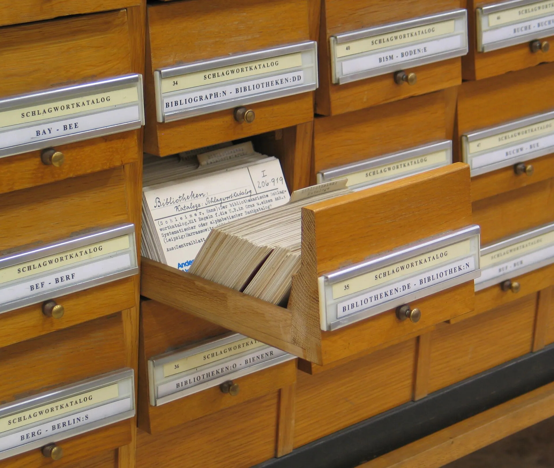 An open drawer of a library card catalogue, full of index cards