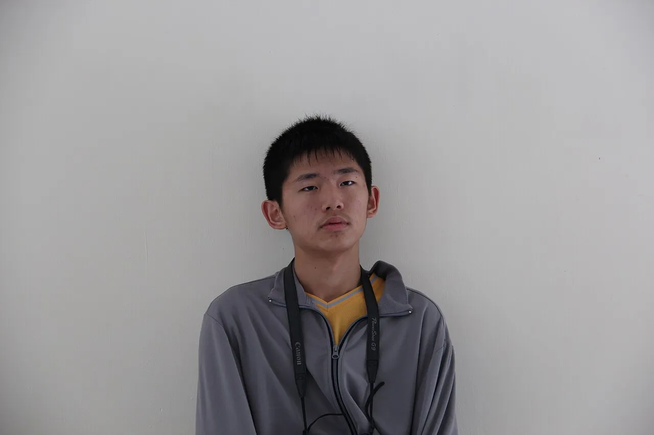 A young man staring blankly at the camera while an arrow labelled whoosh flies just over his head